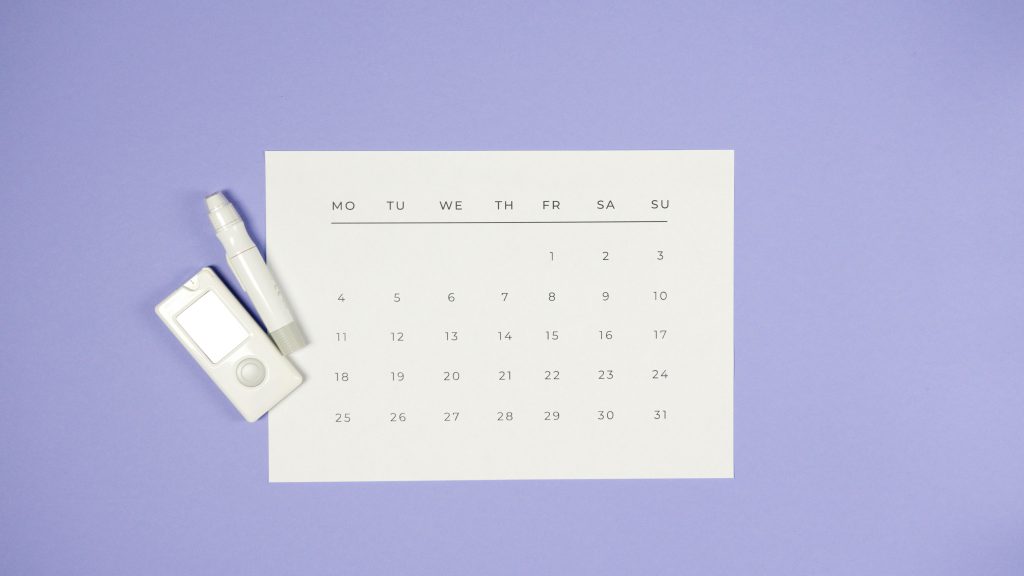 Un calendario minimalista con un dispositivo di misurazione, che rappresenta la pianificazione dei cicli e dei protocolli per i peptidi