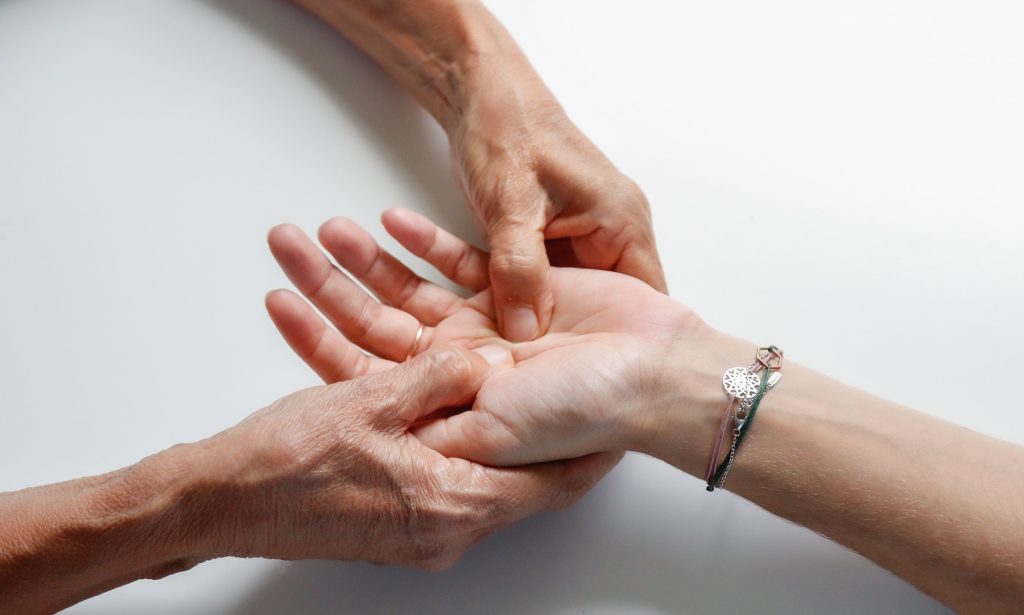 Mani anziane che tengono una mano giovane, a simboleggiare il processo di invecchiamento e la cura della pelle con i peptidi.